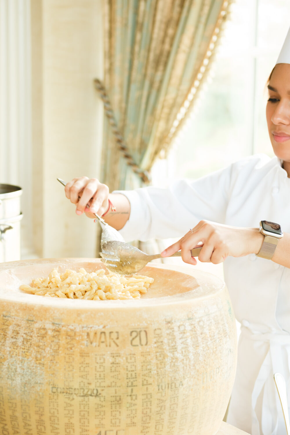 A woman is preparing pasta in a large pot.