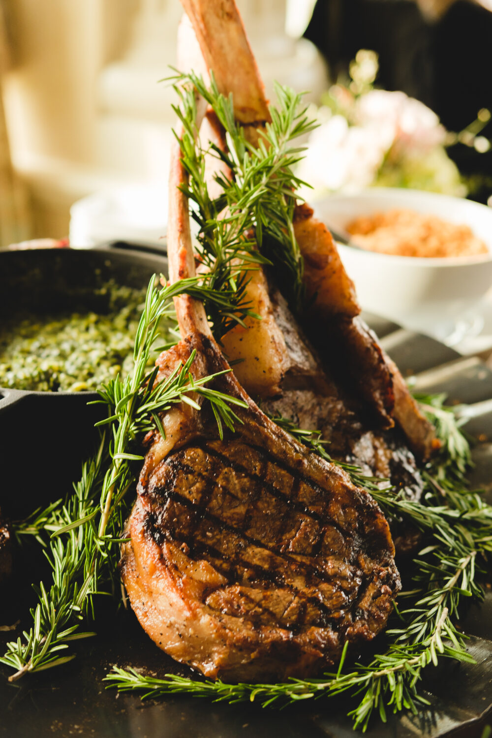 A plate of grilled lamb chops with rosemary sprigs.