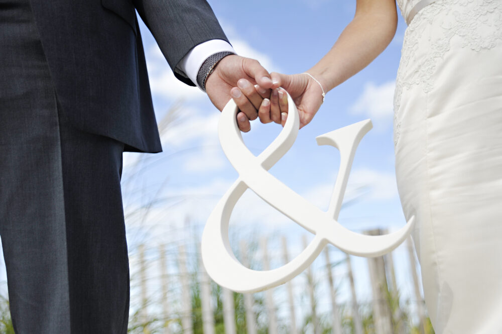 A bride and groom holding hands.