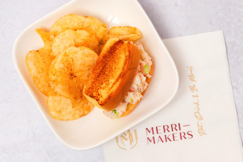 A sandwich with chips and a napkin on a plate.